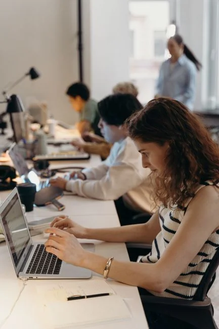 A streamlined desk arrangement with two monitors, a keyboard, mouse, and notebook designed for productivity.